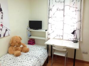 萨拉曼卡托莱克拉维洛公寓的一张桌子旁的床上的泰迪熊