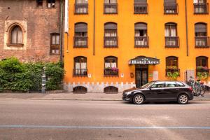 米兰米兰战神酒店的停在黄色建筑前面的黑色汽车