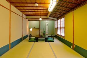 京都京都满月住宿加早餐旅馆的配有桌椅和黄色墙壁的客房