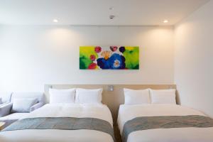 别府戴衣提别府酒店的墙上画画的房间里设有两张床