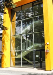 塔林JK曼尼库旅舍的黄色的建筑,窗户上有楼梯