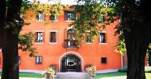 Chiópris-Viscone奇奥里奇别墅 的橙色的建筑,设有门和庭院
