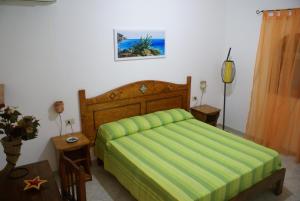 兰佩杜萨Le Anfore Villette的一间卧室配有一张带绿床罩的床