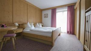 圣克里斯蒂娜Hotel Garni Ruscel的酒店客房设有床和窗户。