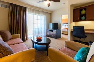 卡尔斯巴德Marbrisa Carlsbad Resort的一间客厅,客厅配有沙发和一张桌子,位于酒店的房间