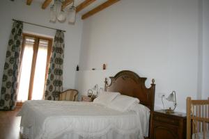 Mahora马约拉之家酒店的一间卧室配有一张带白色床单的床和一扇窗户。
