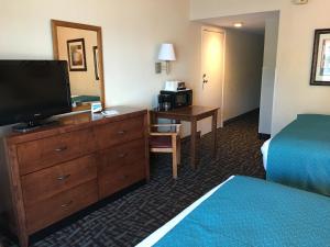 克利尔沃特峡湾美景酒店 - 海滩的酒店客房设有电视、床和书桌