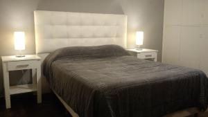 科尔多瓦Nueva Córdoba Rondeau的一间卧室配有2个床头柜、1张床和2盏灯。