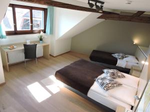 沃韦奥伯格康姆纳尔圣勒日酒店的一间卧室设有两张床、一张桌子和窗户。