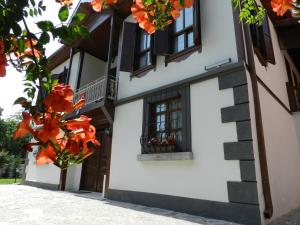 萨潘贾阿斯里贝可纳吉旅馆 - 仅限成人的白色的建筑,有窗户,有橙色的鲜花