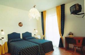 圣乔瓦尼·罗通多Bike-Hotel Abete的一间卧室配有蓝色的床和电视
