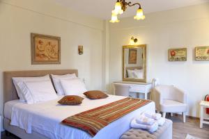 KaléntzionAlexandra Hotel的卧室配有带毛巾的大型白色床