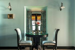 阿姆波尔Fort Tiracol Heritage Hotel的一间带桌子和两把椅子的用餐室以及窗户。