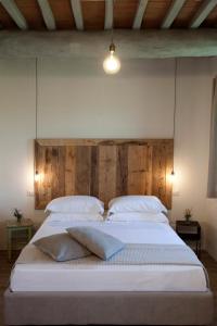 马利亚诺因托斯卡纳Casale Sterpeti的卧室配有一张带白色床单和枕头的大床。