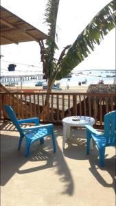 洛佩斯港海蒂旅馆的一个带两把椅子和一张桌子的庭院和一棵棕榈树