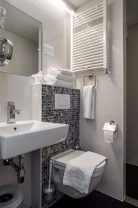 阿姆斯特丹拉兰特酒店的白色的浴室设有水槽和卫生间。