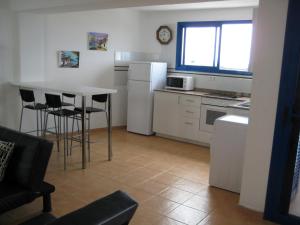 奥尔索拉Mirador del Roque的带桌椅的厨房以及带白色家电的厨房。