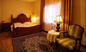 Ķegums奧斯克洛斯酒店的一间卧室配有一张床、一把椅子和一盏灯