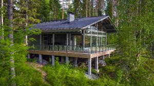 凯乌鲁Mustikkakallio Luxury Villa的树林中的房屋,带围板