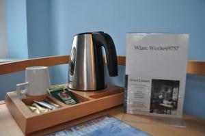 韦尔特卡拉蒙经济型酒店（客房&早餐）的茶壶和桌子上的盒子