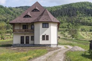 StrîmturaPensiunea Sanziene的山坡上白色的房子,屋顶为棕色