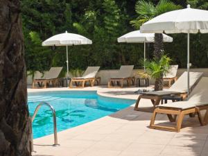 法扬斯欧利维酒店的一个带躺椅和遮阳伞的游泳池