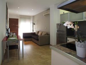 穆尔西亚Apartamentos Amanecer JC1的厨房以及带沙发和桌子的客厅。
