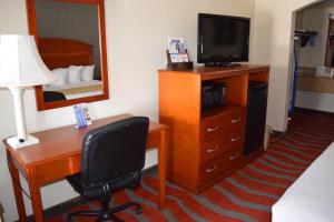 诺曼Travelodge Inn & Suites by Wyndham Norman的酒店客房设有书桌、电视和卧室