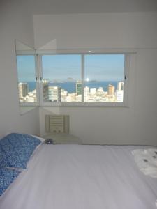 里约热内卢Ipanema's heart的白色的卧室设有床和窗户