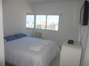 里约热内卢Ipanema's heart的卧室配有白色的床和窗户。