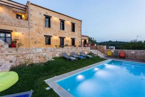 AchladesERONDAS Cretan Country Villas的一座别墅,在一座建筑前设有一个游泳池