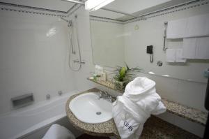 巴勒莫阿斯托瑞亚宫酒店的白色的浴室设有水槽和淋浴。