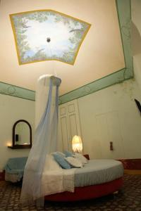 科拉托Locus Amoenus Luxury Rooms的一间卧室设有一张带天花板的床