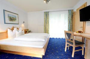 伊施格尔Hotel Garni Valülla的配有一张床和一张书桌的酒店客房