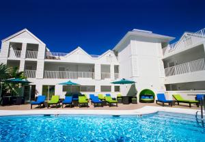 基韦斯特银色棕榈树酒店的大楼前的带椅子和遮阳伞的游泳池