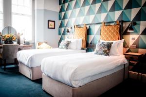 泰晤士河畔金斯顿昆世海德酒店的一间酒店客房,房间内设有两张床