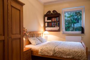 索波特Apartament Mundus的一间卧室配有一张带窗户和书架的床