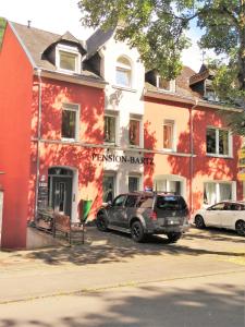 特拉本特拉巴赫Pension Bartz的停在红色建筑前面的汽车