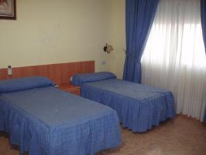 奥卡尼亚赫尔马诺斯公寓酒店的酒店客房设有两张床和窗户。