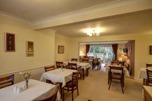 布里克瑟姆Churston Way Lodge Guest House的用餐室配有桌椅