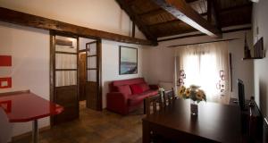 贝尔蒙特Casa Rural Casona la Beltraneja的客厅配有红色的沙发和桌子