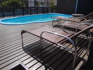 福塔莱萨Apartamento Em Andar Alto com Vista Mar Meireles的游泳池旁的长凳
