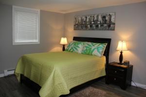 Stratford瑟仁迪勃住宿加早餐旅馆的一间卧室配有一张带绿床罩和两盏灯的床。