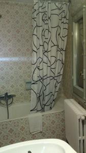 Aixovall普拉堡酒店的浴室设有淋浴帘,位于水槽旁