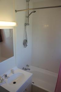 奥克兰机场金星汽车旅馆的白色的浴室设有水槽和淋浴。