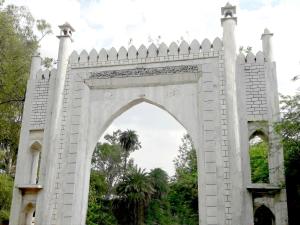 阿格拉Taj Castle A Boutique Homestay的公园内有白色围栏的拱门