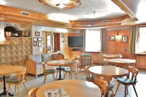 利维尼奥加尼阿尔普兰酒店的餐厅设有桌椅和沙发。