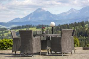 扎布Hotel REDYK Ski&Relax的一张桌子和椅子,背景是群山