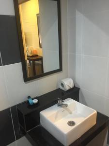 珍南海滩萨伊哈宾馆的浴室设有白色水槽和镜子