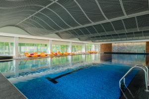 尤尔马拉斯玛拉里卢普SPA&会议酒店的一座大型游泳池,里面设有橙色椅子